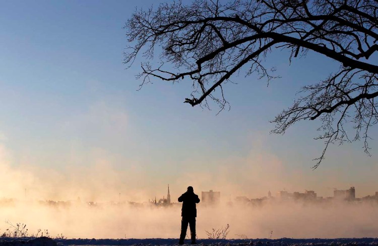Todd Chase of Gorham takes photos of the city skyline emerging from sea smoke over Back Cove at sunrise during single-digit weather on Tuesday, January 2, 2018. Chase said he frequently pulls over to take photos during his commute. "I like to snap a shot every time I see something unusual," he said. "This is one of those mornings." Staff photo by Ben McCanna