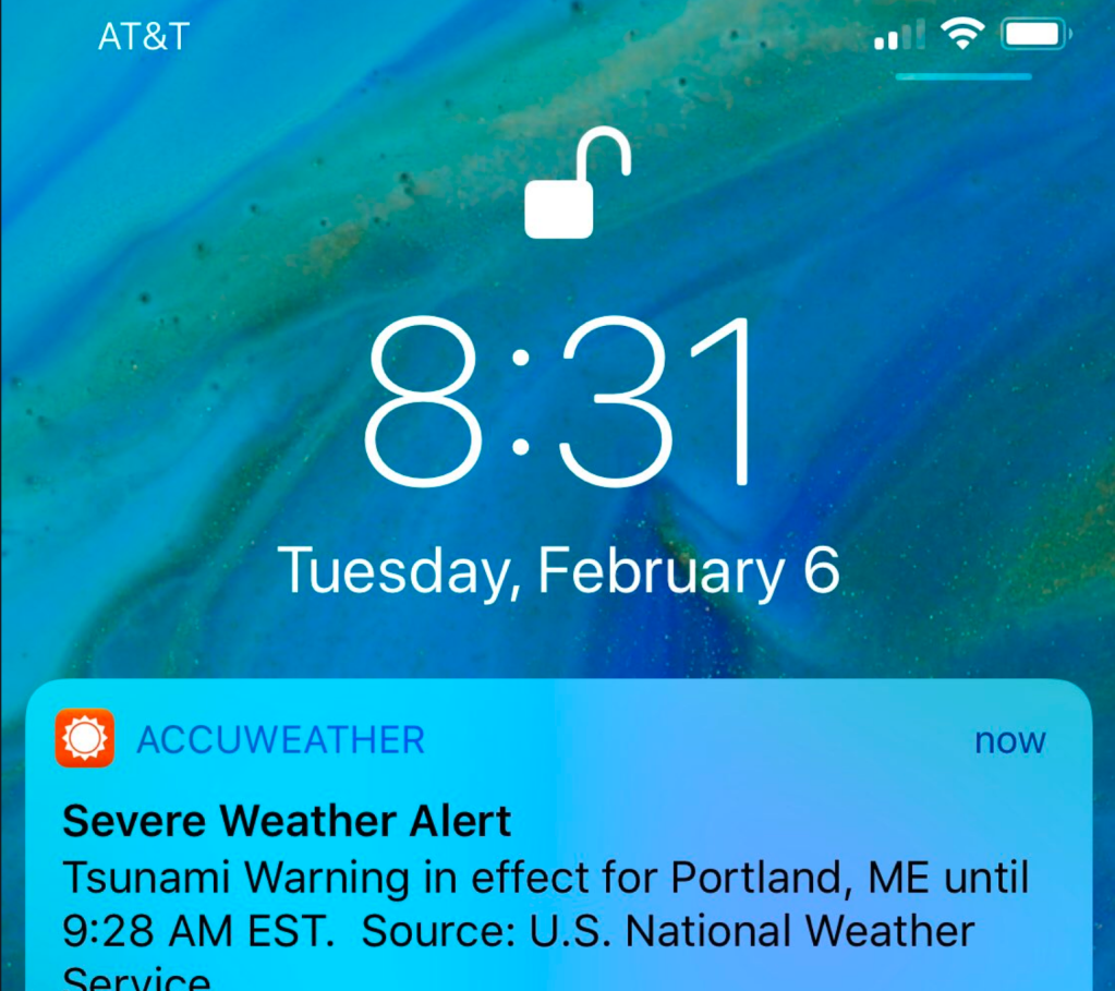 A smartphone screenshot shows the false tsunami alert sent out on the morning of Tuesday, February 6, 2018.