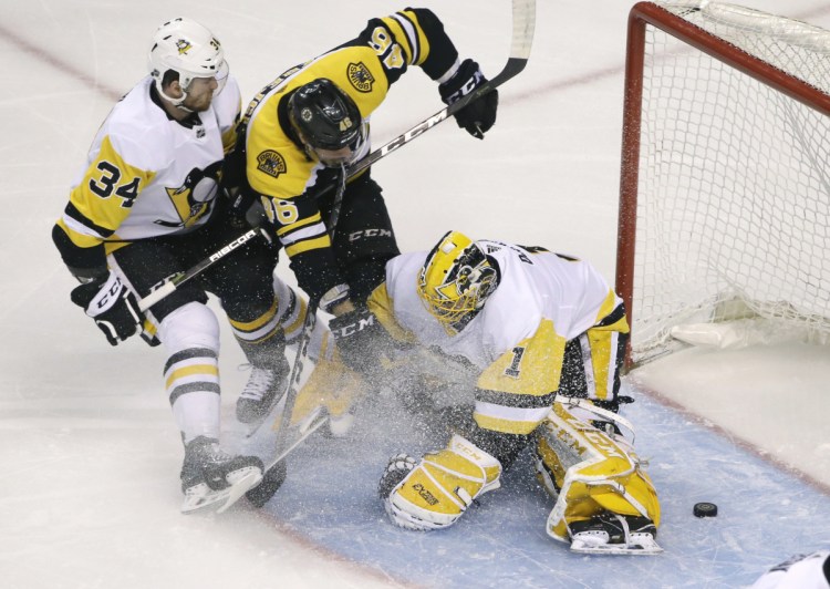 Boston's David Krejci fends off Pittsburgh's Tom Kuhnhackl and scores one of his three goals Thursday night, slipping the puck past goalie Casey DeSmith in the first period.