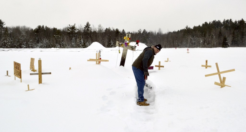 Fred Butman clears a path in the snow at the memorial he and his family built in Canaan, N.H., for his stepson Jesse James Champney, who was shot dead by police.