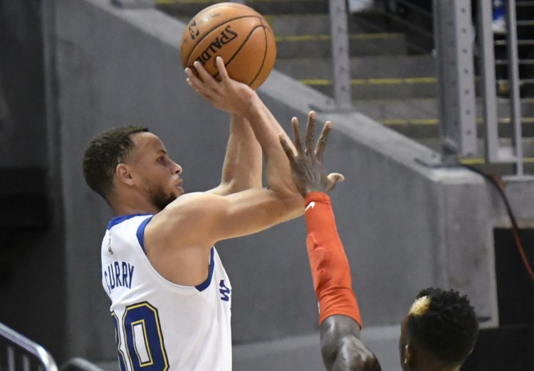 Warriors guard Stephen Curry shoots from the 3-point line as Hawks guard Dennis Schroder defends during the Golden State's 114-109 win in Atlanta on Friday. Curry scored 28 points but left the game in the third quarter.