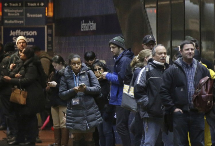 Passengers wait for SEPTA regional rail trains, most of which were suspended, in Jefferson Station in Philadelphia on Friday. Travel continued to be a challenge on Saturday.