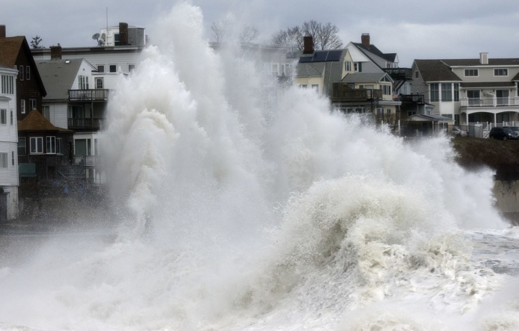 A large wave crashes into a seawall in Winthrop, Mass., Saturday, a day after a nor'easter pounded the coast.