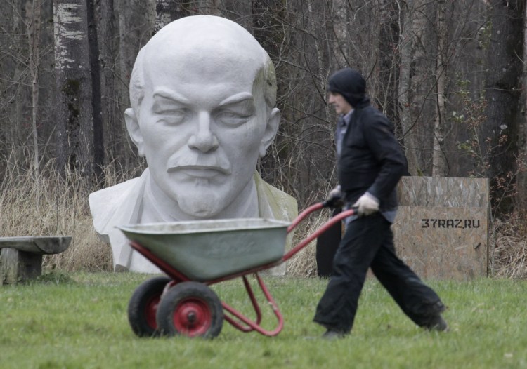 A worker walks past a statue of Soviet Union leader Vladimir Lenin last year at the Lenin Hut Museum in a forest near Razliv Lake, outside St. Petersburg, Russia. 
