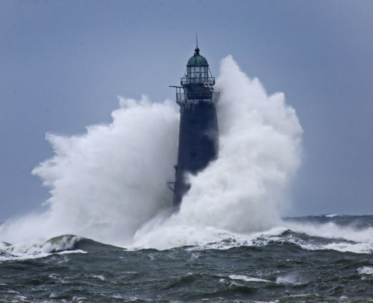 Waves crash against Minot Light off Scituate, Mass., on Sunday as winds continued to batter the coast. The 89-foot-tall lighthouse was built in 1855.
