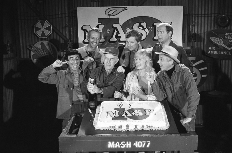Jamie Farr, from front left, plugs his ears as cast members of the "M.A.S.H" television series Harry Morgan, Loretta Swit, William Christopher and, in back from left, Mike Farrell, Alan Alda and David Ogden Stiers celebrate during a party on the set of the popular CBS program in Los Angeles. Stiers, a prolific actor best known for playing Maj. Charles Winchester, has died at 75.