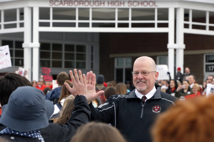 Scarborough High School Principal David Creech, who resigned suddenly amid controversy and then tried to rescind his action, gets high-fives from students Feb. 26. A former student wrote from 517 miles away to support Creech.