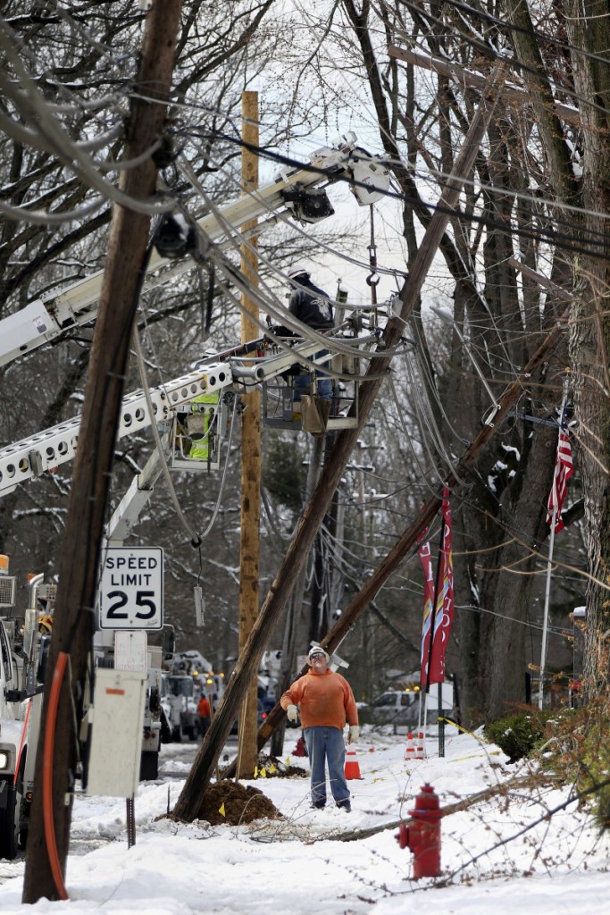 Crews work to replace utility poles in Fairless Hills, Pa., on Thursday.