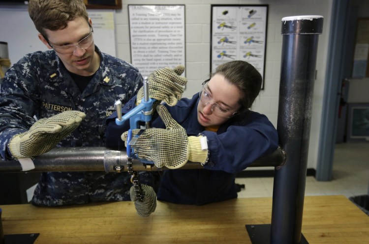 Navy Ensigns Thomas Patterson of Anaheim, Calif., and Megan Stevenson of Raymond, Maine, train to patch pipe leaks last year at the Naval Submarine School in Groton, Conn.
