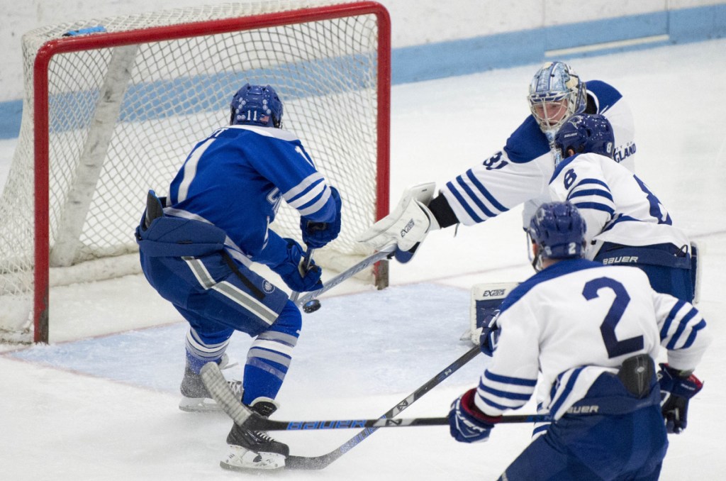 Colby College's Kienan Scott (11) scores a goal on University of New England goalie Tate Sproxton (31) in the second period Saturday in at the Alfond Youth Forum in Biddeford.