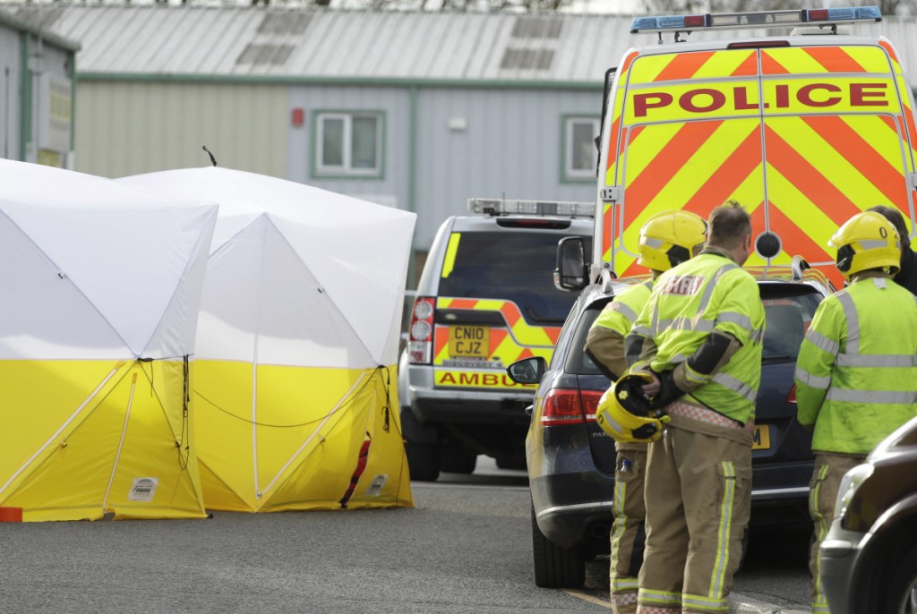 Officials at a vehicle recovery business in Salisbury, England, Tuesday, look for clues in the poisoning of a former spy and his daughter. The father and daughter are in critical condition.