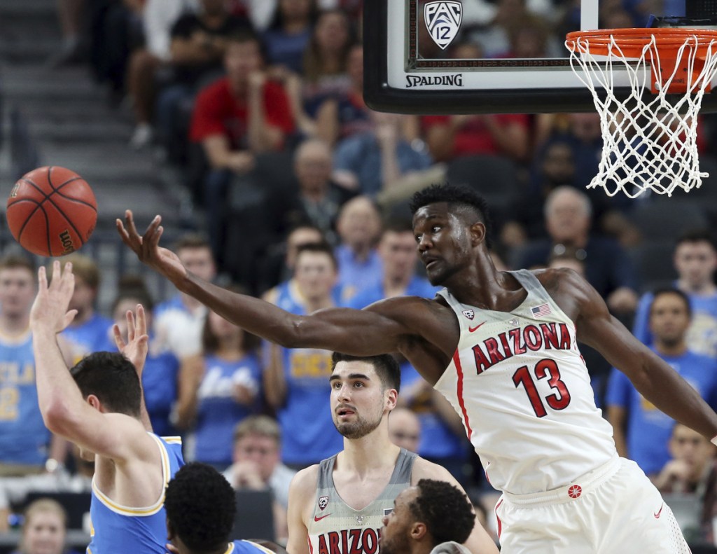 Arizona's Deandre Ayton (13) reaches for a rebound during the second half of the team's NCAA college basketball game against UCLA in the semifinals of the Pac-12 men's tournament Friday, March 9, 2018, in Las Vegas. Arizona won 78-67 in overtime. (AP Photo/Isaac Brekken)