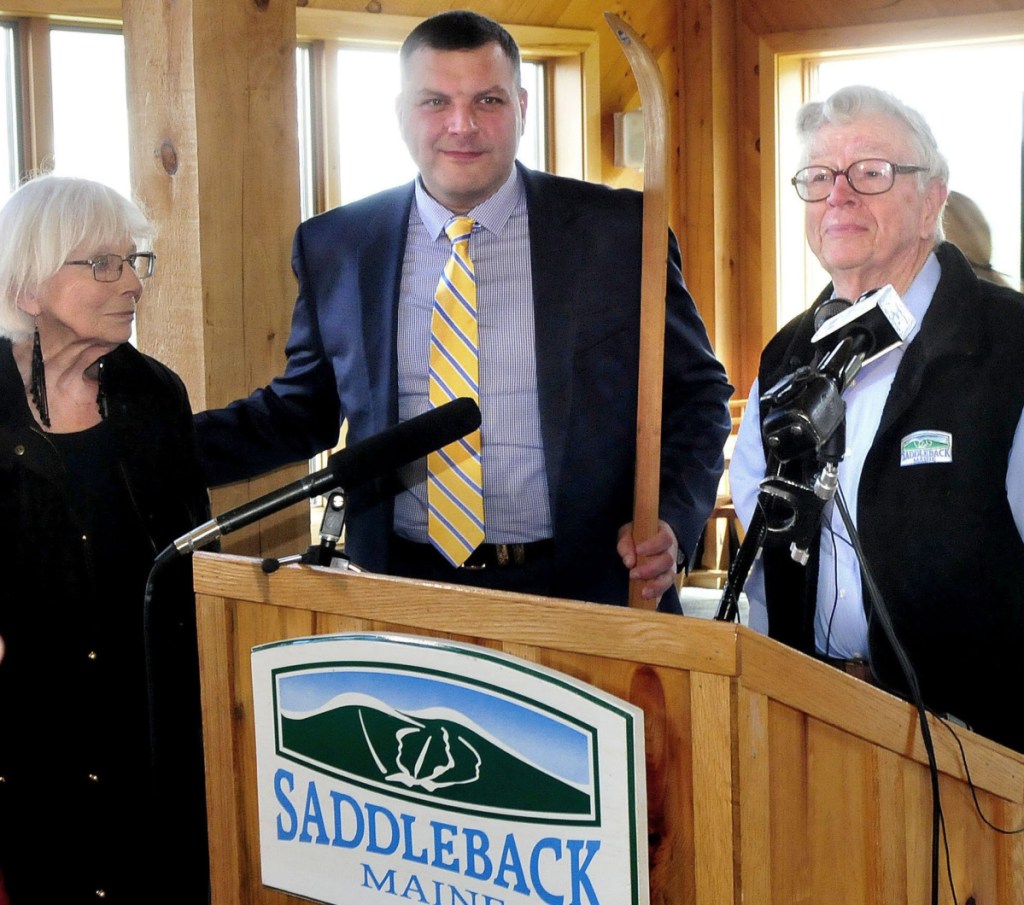 Saddleback owners Irene and Bill Berry pass the traditional wooden ski to Sebastian Monsour, center, chief executive officer of the Majella Group, during the sale announcement at the ski resort last year. The sale has yet to be completed and Monsour now faces charges in Australia.