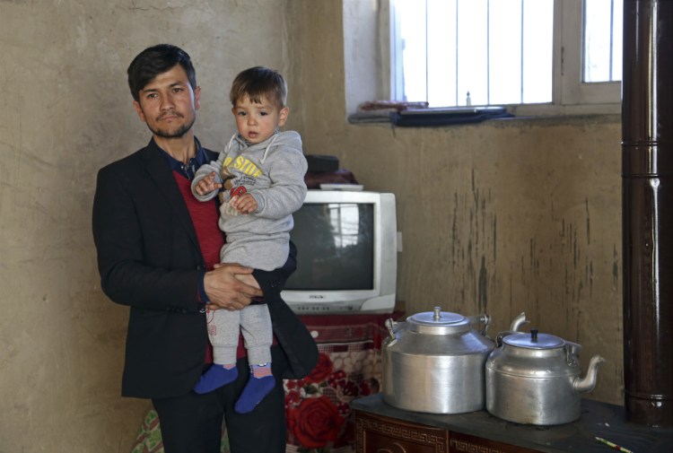 Asadullah Poya with his 18-month-old son Donald Trump, poses for a photograph at their rented house in Kabul, Afghanistan.