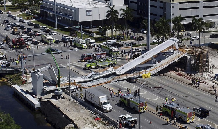 Emergency workers respond after the collapse of a new pedestrian bridge at Florida International University in Miami on Thursday. The bridge crushed multiple vehicles and killed at least four people.