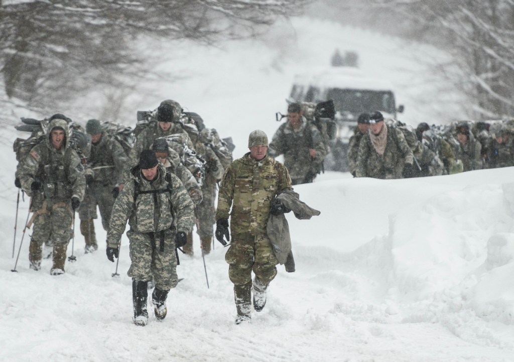 Vermont National Guard soldiers on a training exercise emerge from a closed section on Vermont 108 in Cambridge, Vermont, just below Smuggers Notch on Wednesday night after six soldiers were swept about 900 feet by an avalanche.