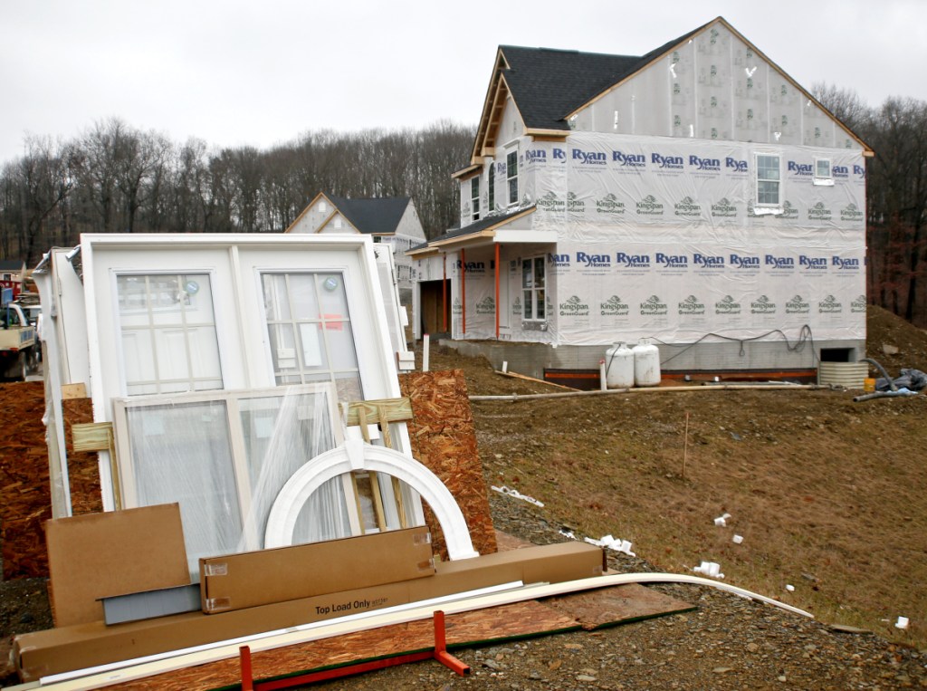 Building materials are piled near a home-construction site in Zelienople, Pa., last month. The Commerce Department on Friday reported on February's home construction data in the U.S., saying that builders have shifted focus from multifamily units to single-family houses.