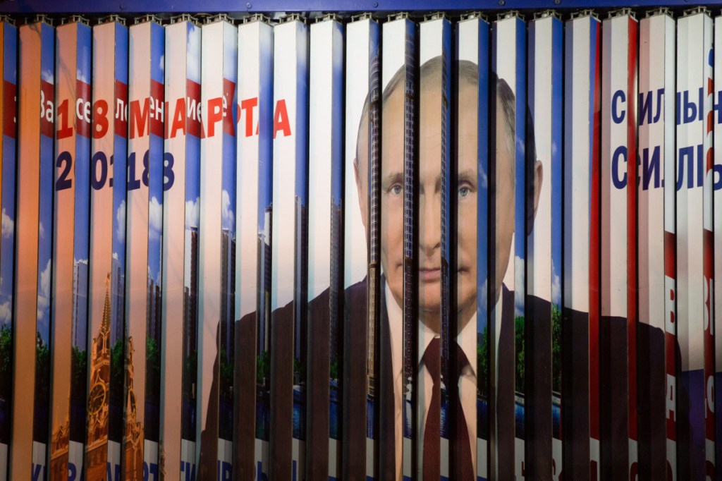 Panels rotate on an election campaign billboard poster featuring incumbent Russian President Vladimir Putin in Moscow. A monitoring group says there has been an alarming rise in complaints from employees that their bosses are pressuring them to vote.