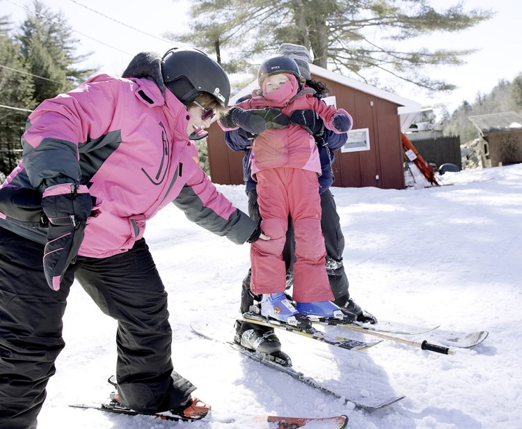 Katie Creedon is helped by her mother, Jessica, left, and ski instructor Heather Stukas at Lost Valley in Auburn on Sunday. Katie has a rare genetic disorder and doctors told her parents it was unlikely she would live to be 5. She turns 6 on Wednesday.