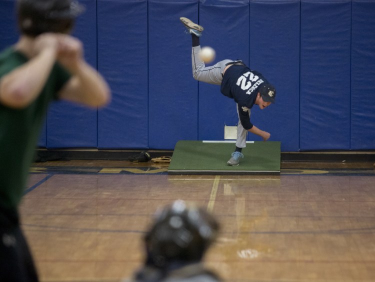 Senior Ethan Belesca, a Yarmouth High baseball pitcher, uses a makeshift mound to get in his work Monday – the first day of conditioning for pitchers and catchers around the state. Yarmouth will seek a second straight Class B state championship this season.