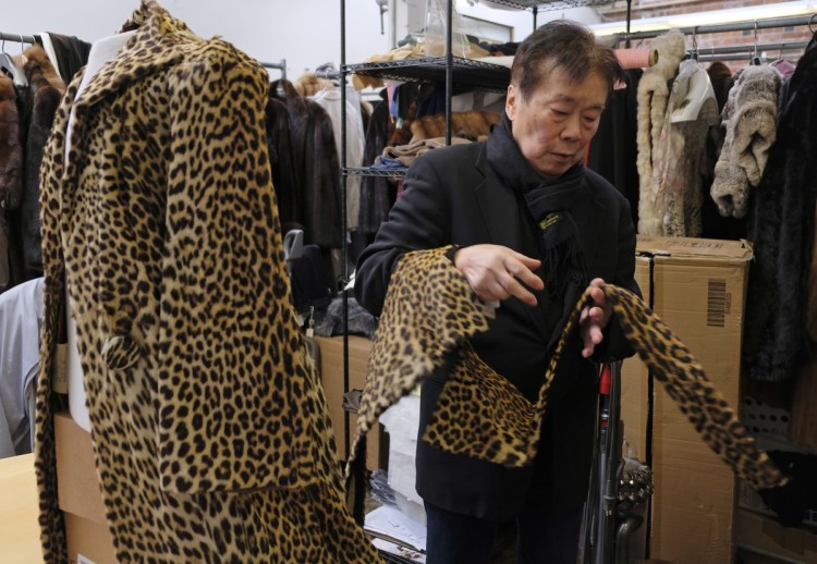 Benjamin Lin looks over a 60-year-old cheetah jacket he is restoring at the B.B. Hawk showroom in San Francisco. A city board voted unanimously to ban the sale of fur Tuesday to the chagrin of some business owners who don't like being told what they can or can't sell.