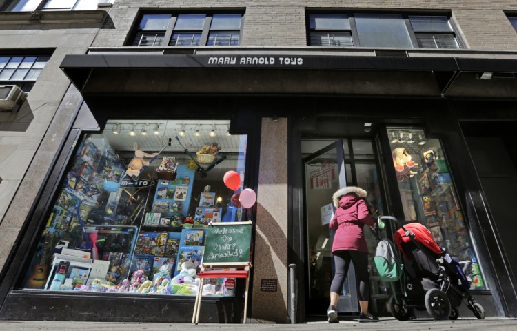A woman pushes a stroller as she enters Mary Arnold Toys in Manhattan's Upper East Side. Many of the store's customers come in every week.