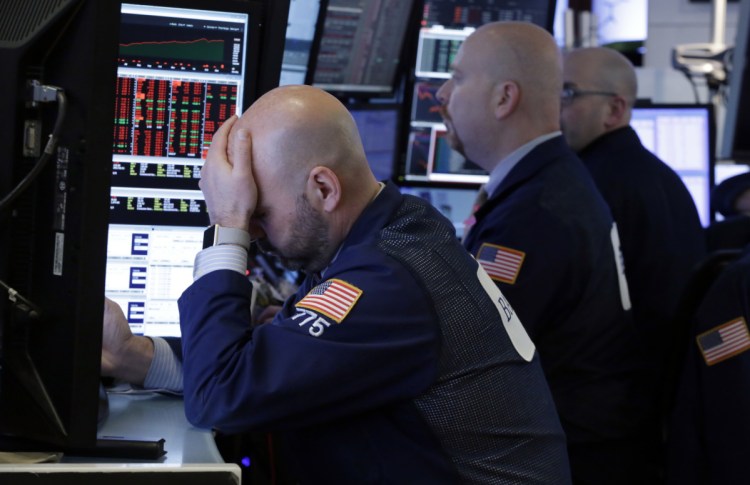 Trader Fred DeMarco, left, works with colleagues in a booth on the floor of the New York Stock Exchange on Thursday.