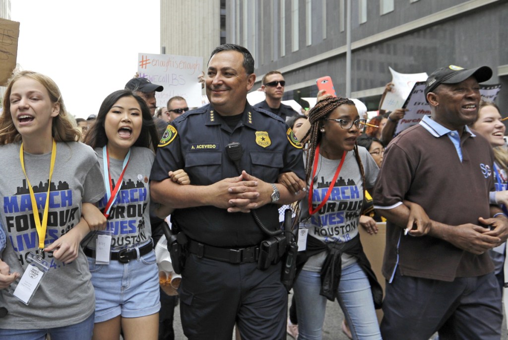 ABOVE: Houston Police Chief Art Acevedo, center, and Mayor Sylvester Turner, far right, join demonstrators during a "March for Our Lives" protest for gun legislation and school safety Saturday in Houston. Turner told the crowd that adults have a responsibility to stand up and protect all children.