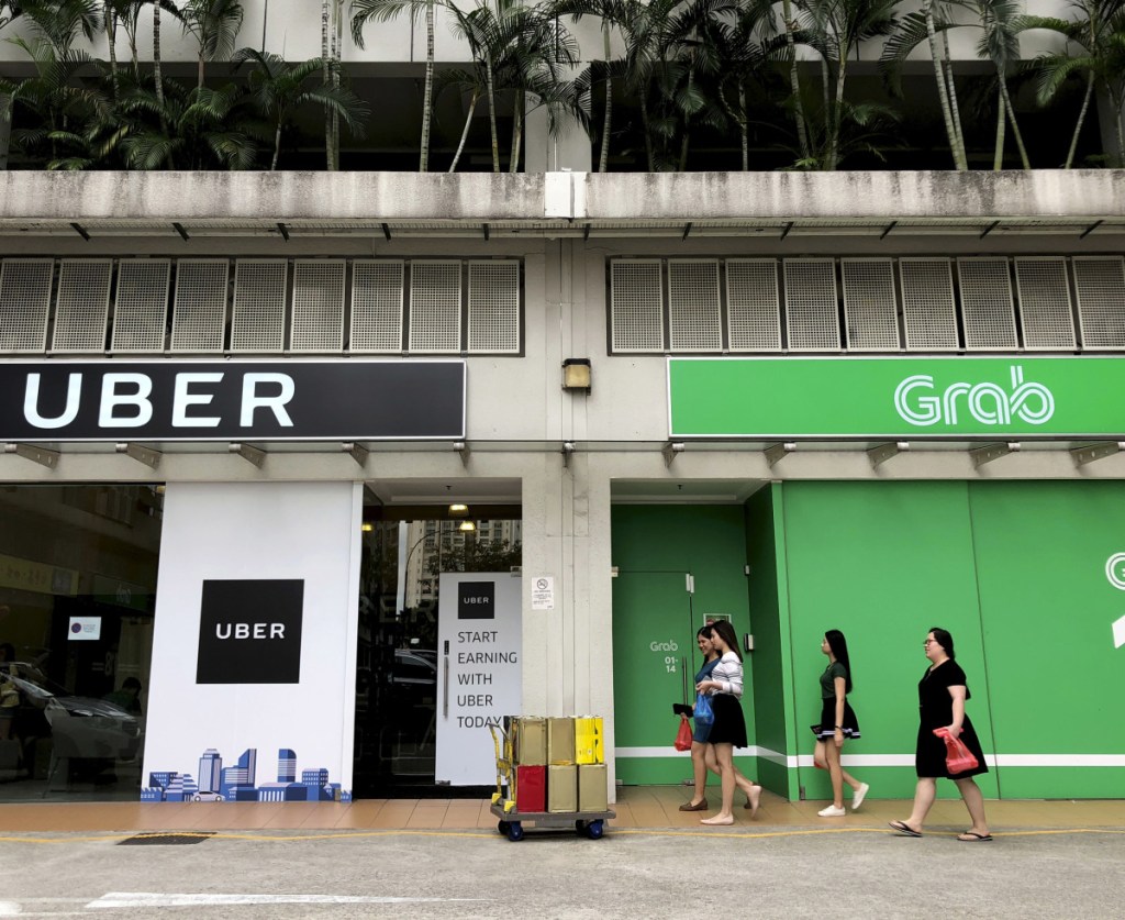 Ride-hailing rivals Grab and Uber have side-by-side offices in Singapore. As part of selling its Southeast Asia operations to Grab, Uber will get a stake in the buyer and a board seat.