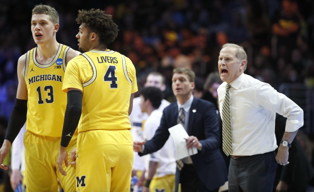 Michigan coach John Beilein, right, yells to players as forwards Moritz Wagner (13) and Isaiah Livers (4) talk during the first half of the team's NCAA men's college basketball tournament regional final against Florida State on Saturday, March 24, 2018, in Los Angeles. (AP Photo/Jae Hong)