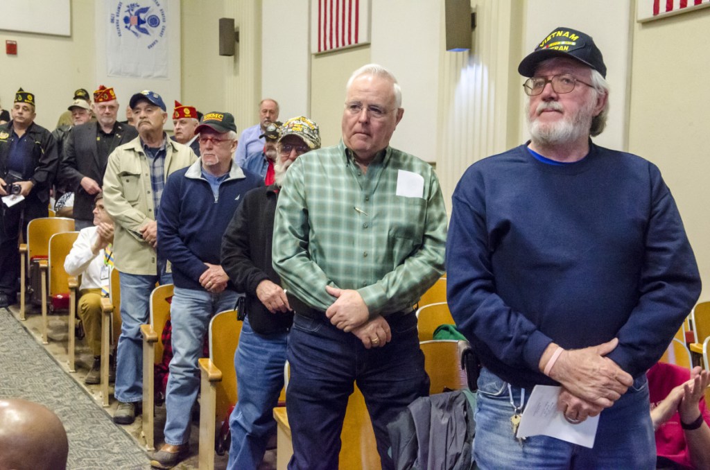 Vietnam veterans stand to be honored Thursday during a of Vietnam War 50th anniversary event at the VA Maine Healthcare Systems-Togus, which includes the federal hospital outside Augusta.