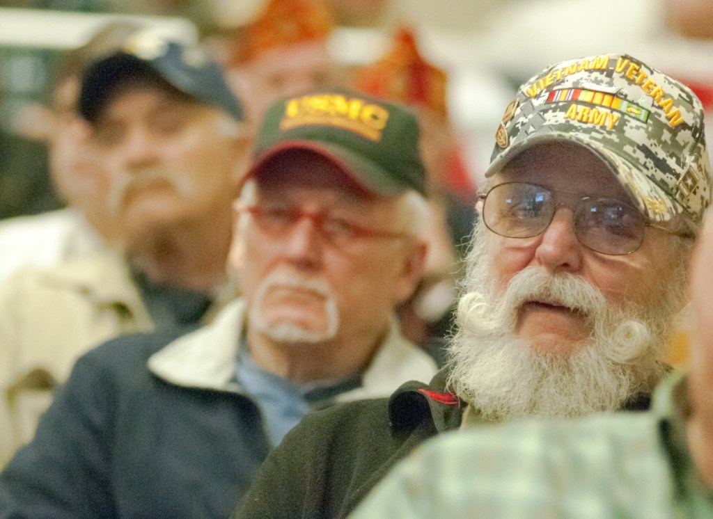 Vietnam War veterans Charlie Smith, of Cushing, center, and Albert Kontrath, of Wiscasset, listen to speeches Thursday during a Vietnam War 50th anniversary event at the VA Maine Healthcare Systems-Togus, which includes the federal hospital outside Augusta.