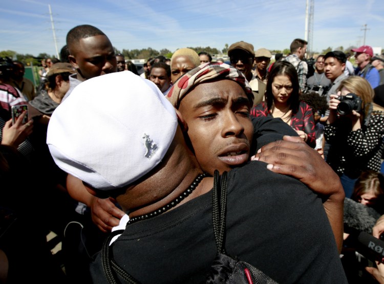 Stevante Clark, the brother of police shooting victim, Stephon Clark, is consoled by a supporter after Stephon Clark's funeral on Thursday in Sacramento, Calif.