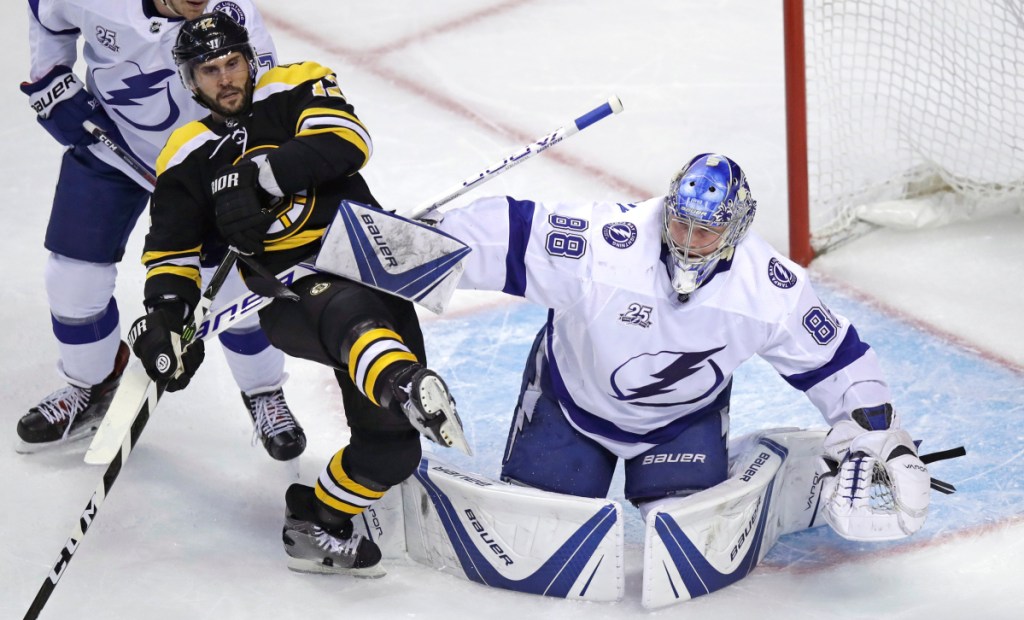 Tampa Bay Lightning goaltender Andrei Vasilevskiy (88) clears back Boston Bruins right wing Brian Gionta, left, during the first period of an NHL hockey game in Boston, Thursday, March 29, 2018. (