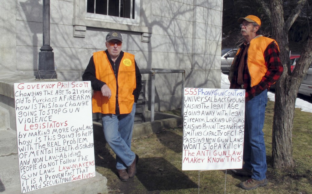 Bert Saldi, left, of Barre, Vermont, stands with another protester who wouldn't give his name, outside the Vermont Statehouse on Tuesday in Montpelier, Vt. They were protesting a measure that would raise the legal age for gun purchases, expand background checks and ban high-capacity magazines and rapid-fire devices known as "bump stocks."