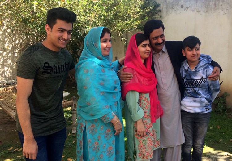 Malala Yousafzai, center, gathers with her family during a visit to her hometown Mingora for the first time since a Taliban militant shot her there in 2012 for advocating girls' education.