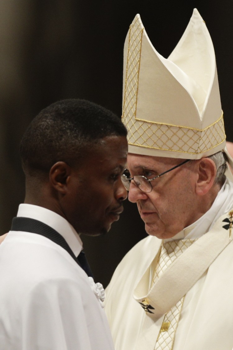 John Ogah passes by Pope Francis after being baptized Saturday. Ogah also now has a job and a home.
