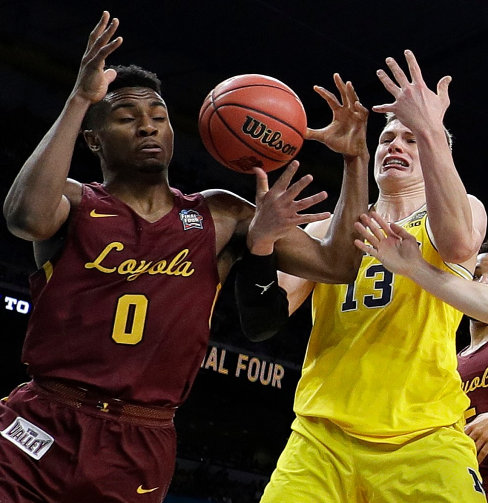 Loyola-Chicago's Donte Ingram, left, and Clayton Custer, right, battle for the rebound against Michigan's Moritz Wagner during the first half in the semifinals of the Final Four NCAA college basketball tournament, Saturday, March 31, 2018, in San Antonio. ()