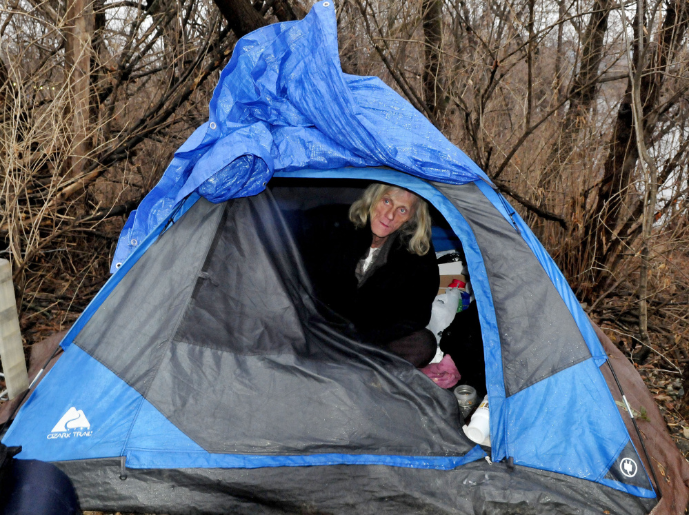 Vaughan Orchard, who is homeless, peers out from his tent where he lives beside the railroad tracks and Kennebec River in Waterville on a cold and rainy Tuesday in December 2015.