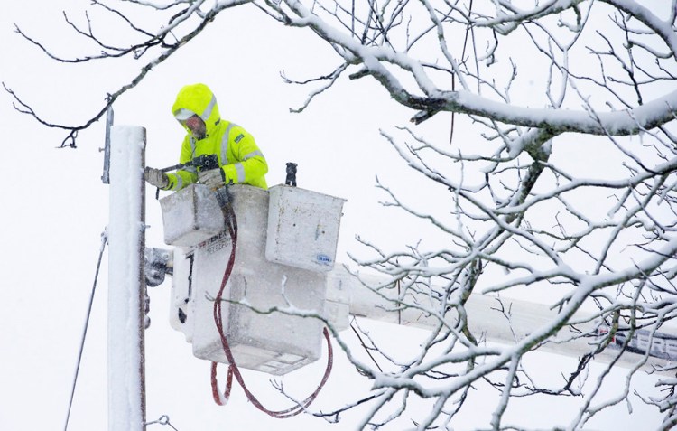 A worker repairs power lines in Norwell, Mass., during the nor'easter that socked New England on Tuesday, knocking out power to tens of thousands. 