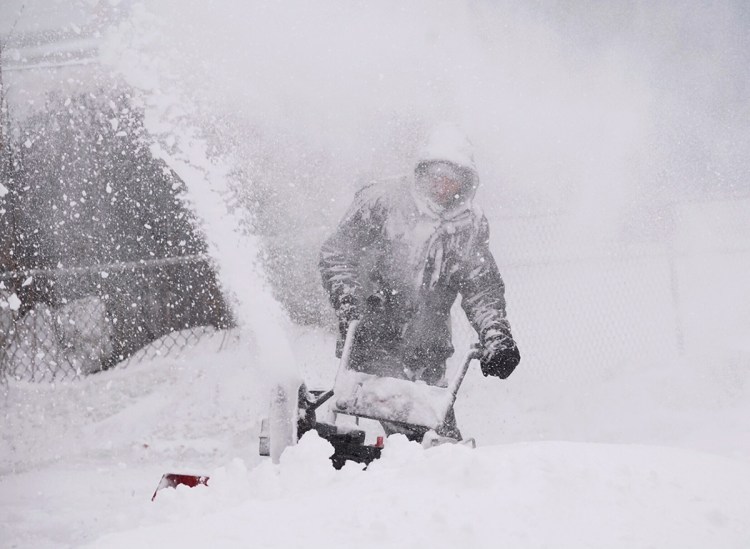 Kyle Binette is surrounded by wind-driven snow as he snow cleared his driveway in Biddeford last March.