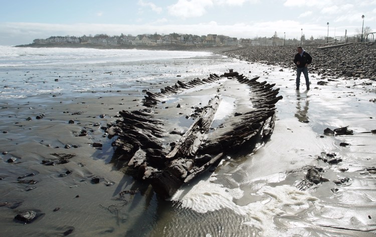 Dan DeButts of Lebanon checks out the shipwreck at Short Sands Beach in York on Monday. The shipwreck was uncovered over the past three days of coastal flooding. The last time it was revealed was in 2013.
