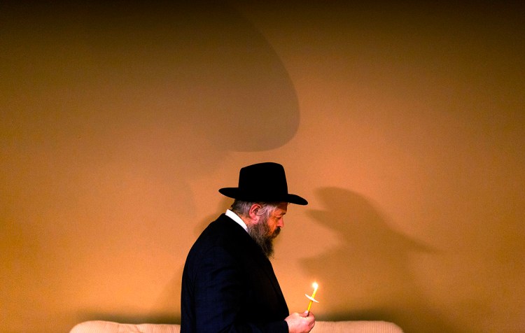Rabbi Moshe Wilansky leads the search of his house for chametz on the night before Passover begins, March, 2018.  The ritual is meant to clean the house of any chametz, or leavened goods, before the start of Passover, because leavened items are not allowed during the holiday. The children hide crumbs of bread through out the house and the bag of bread crumbs is burned the following morning. 