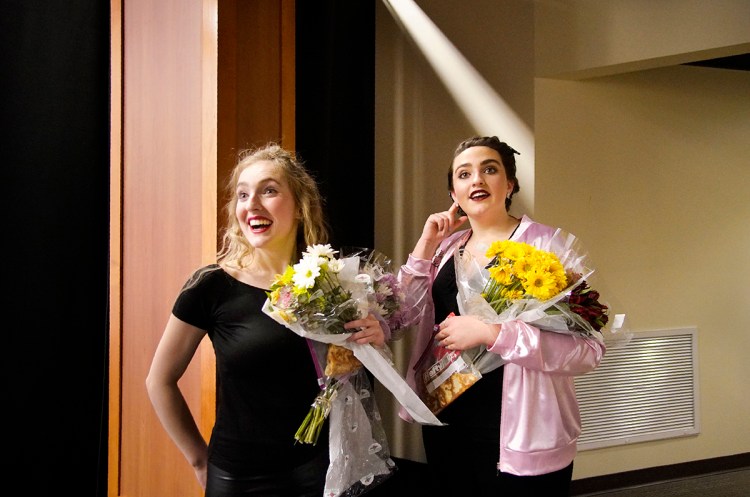 As they return backstage after the opening night performance of the musical Grease at Wells High School on  March 15, 2018, Kylie Belanger, left, and Delaney Bailey listen as people congratulate them on their performances.