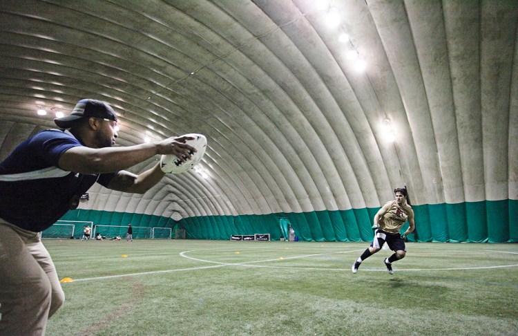 Coach Steven Barker, left, leads Logan Stewart of Hampden in a drill during local tryouts March 11 for Maine's new indoor football team, the Mammoths, at Seacoast United of Topsham. 