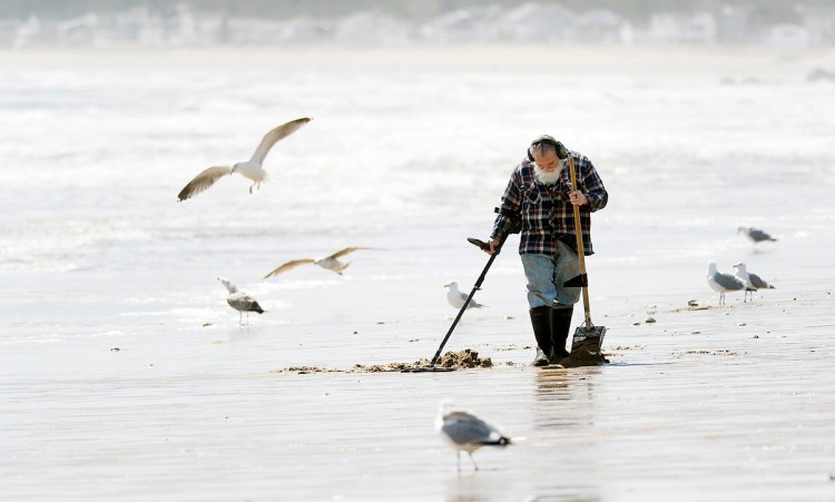Bob Daigle of Biddeford searches for treasures along the beach in Old Orchard Beach March 27, 2018. Old coins, rings and other jewelry items are among some of the items he says he might find. 