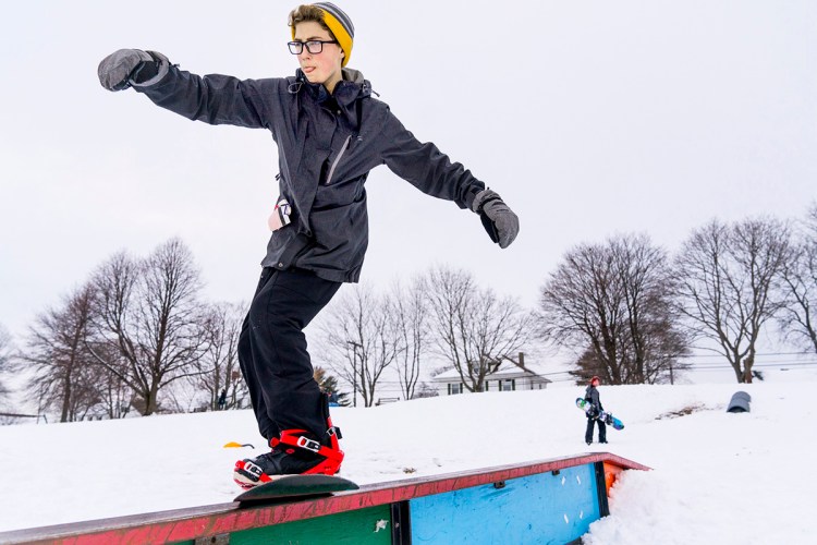 Harrison Fream, 14, of Scarborough, grinds on a rail at Payson Park in Portland as he snowboards with his twin brother, Gordon, after school on March 9. 