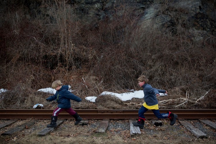 Ben Stevenson, 5, left, and his brother Schuyler Stevenson, 7, jump along the wood railroad ties on the Maine Narrow Gauge Railroad Company track on Feb. 22 in Portland.  