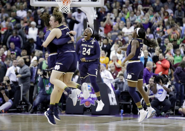 Notre Dame's Arike Ogunbowale (24) celebrates with teammates after making a 3-point basket to defeat Mississippi State 61-58 in the final of the women's NCAA Final Four college basketball tournament, Sunday, April 1, 2018, in Columbus, Ohio. (AP Photo/Ron Schwane)