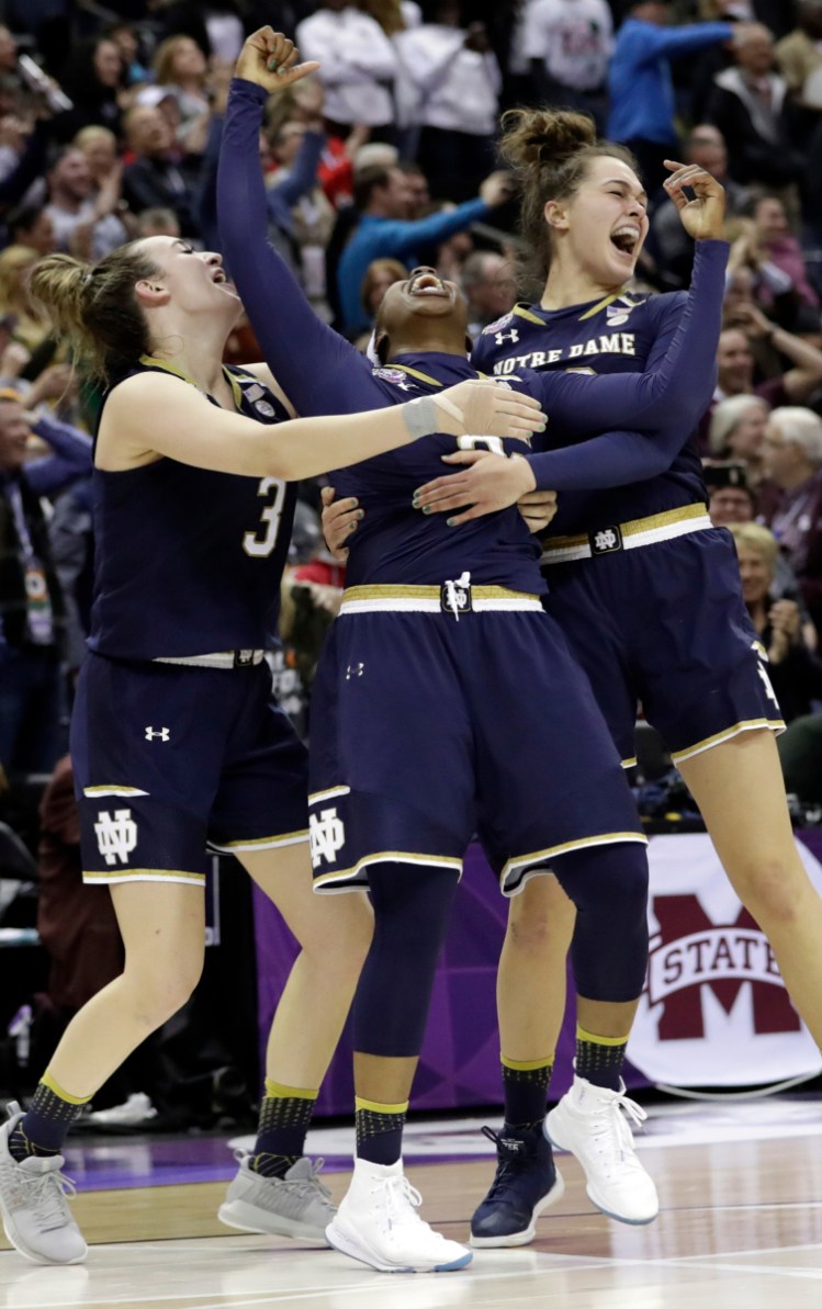 Notre Dame's Arike Ogunbowale, center, celebrates with teammates Marina Mabrey, left, and Kathryn Westbeld after her last-second 3-pointer Sunday gave the Irish their second national title.